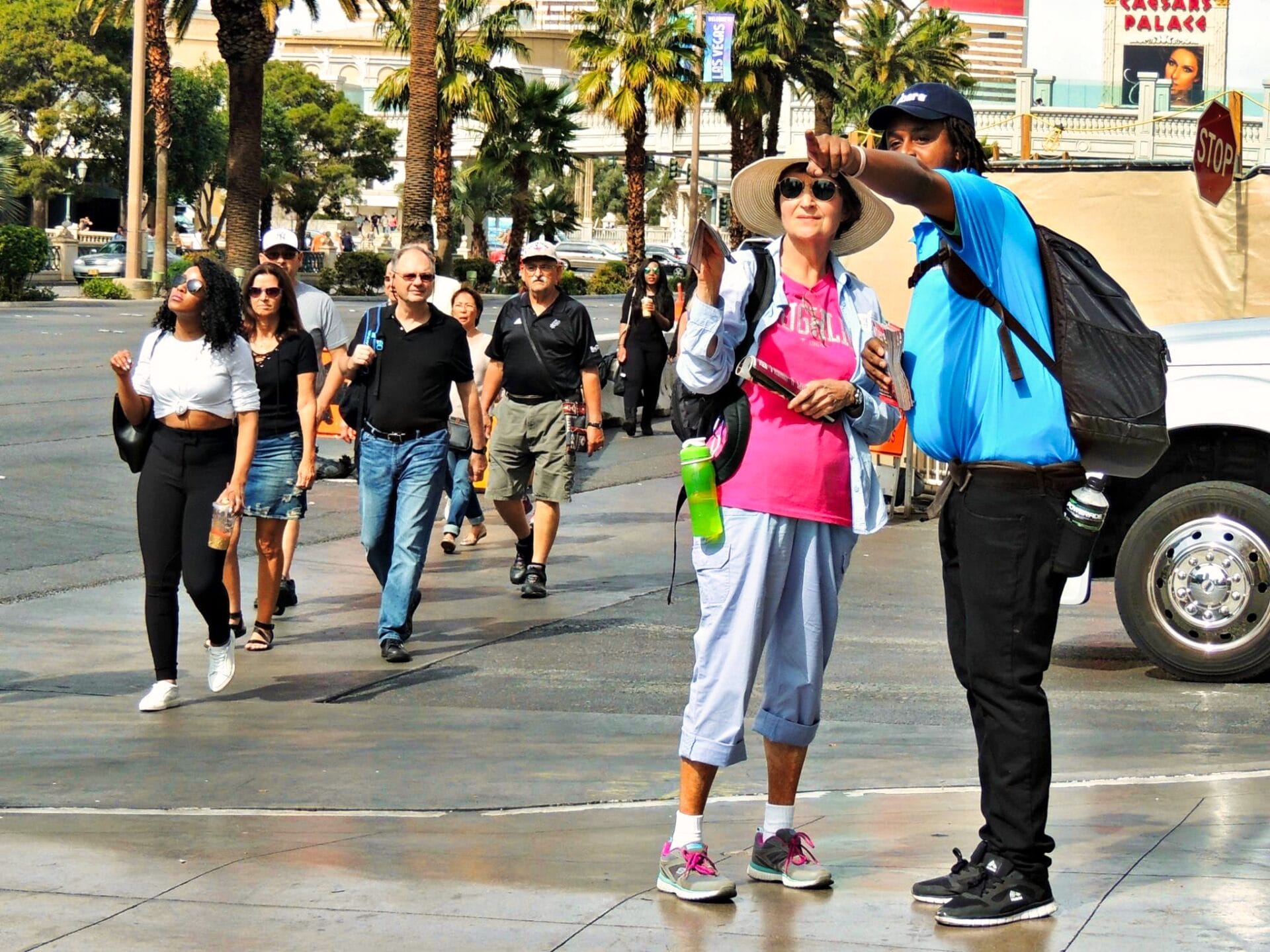 Tour guide assisting woman on sunny city street.