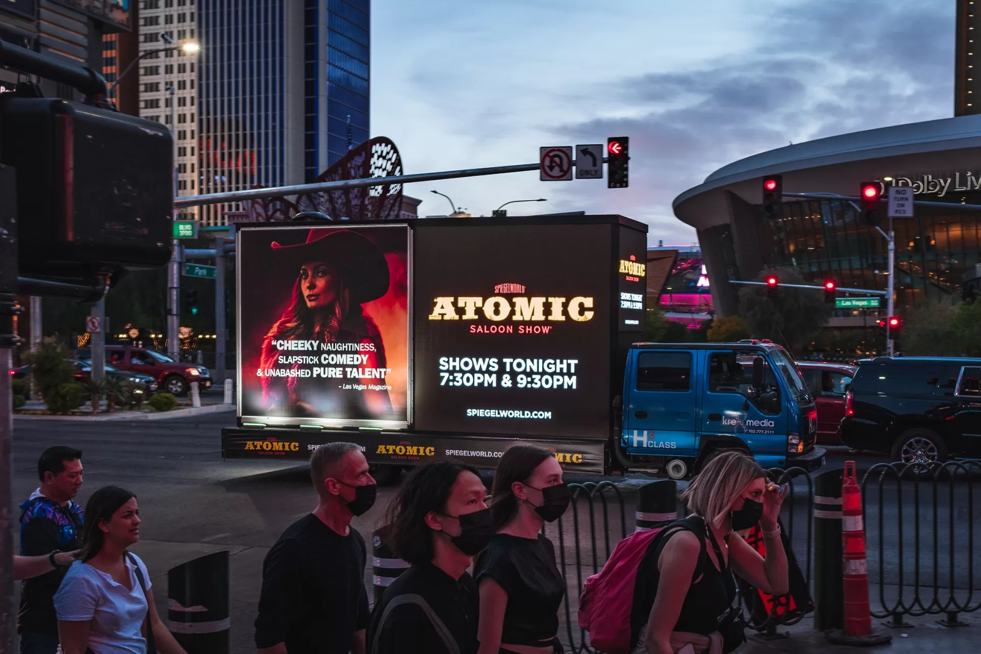 Pedestrians near billboard advertising Atomic Saloon Show.