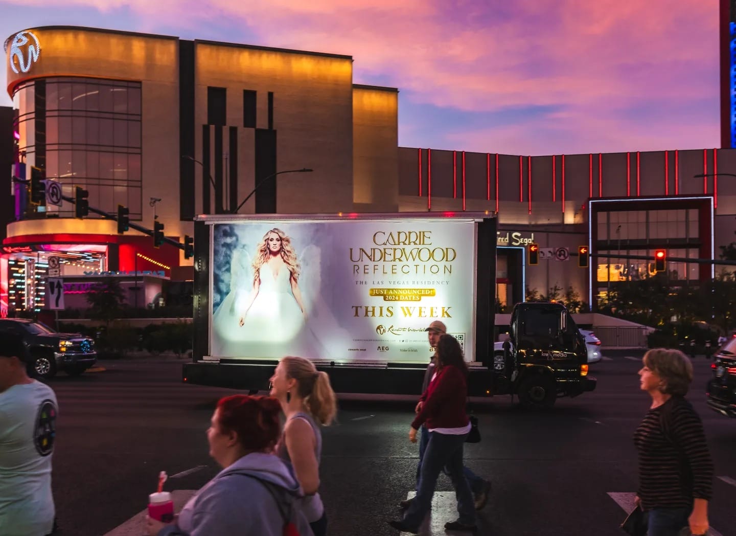 Mobile billboard truck at twilight in city.