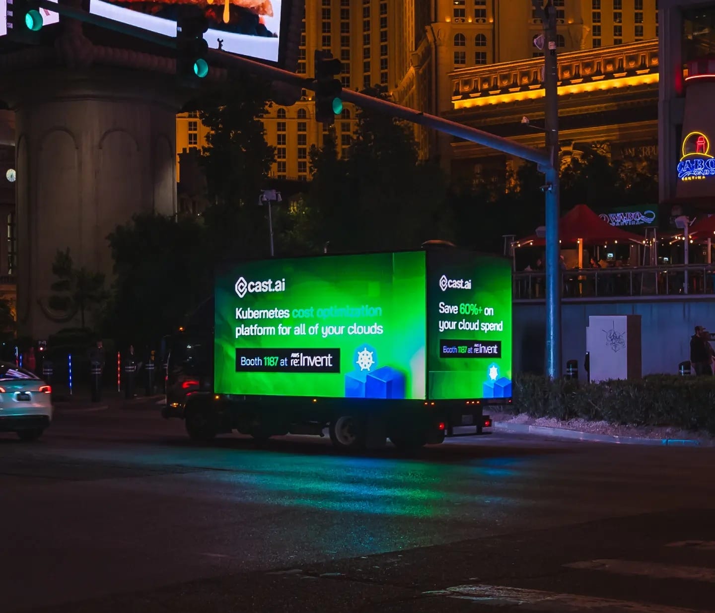 Illuminated billboard truck advertising Kubernetes optimization at night.