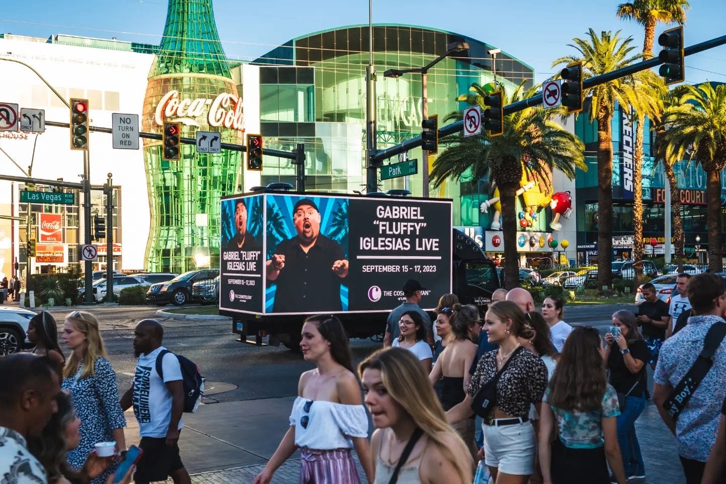 Las Vegas street scene with advertisement truck and pedestrians.