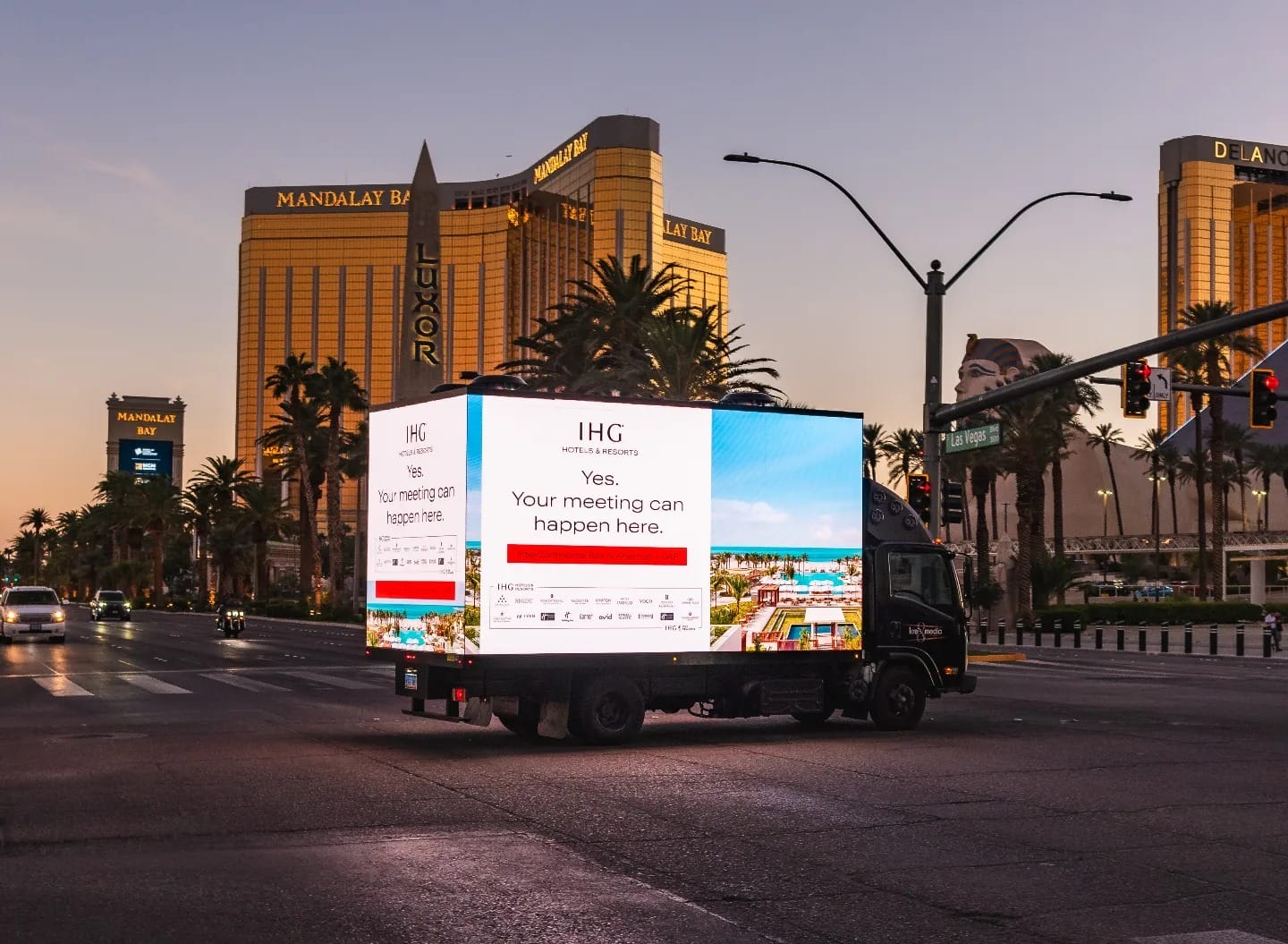 Mobile billboard on Vegas Strip at dusk.