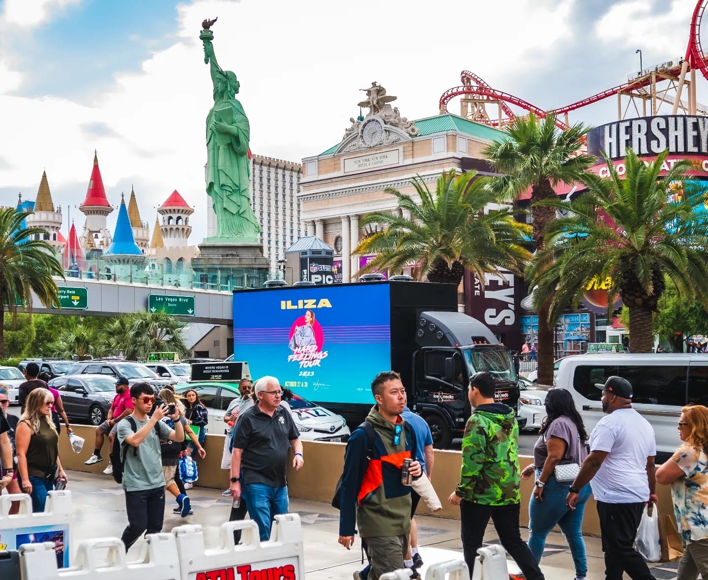 Pedestrians on Las Vegas Strip near replica Statue of Liberty.