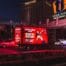 Illuminated Magic Mike billboard truck at night by casino.