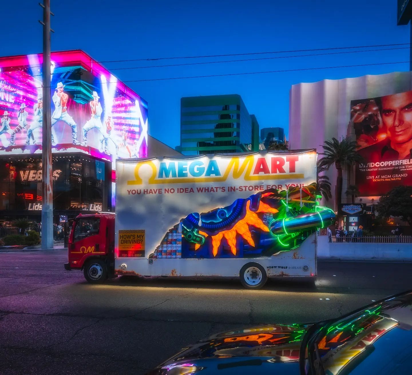 Illuminated advertising truck on vibrant city street at dusk.