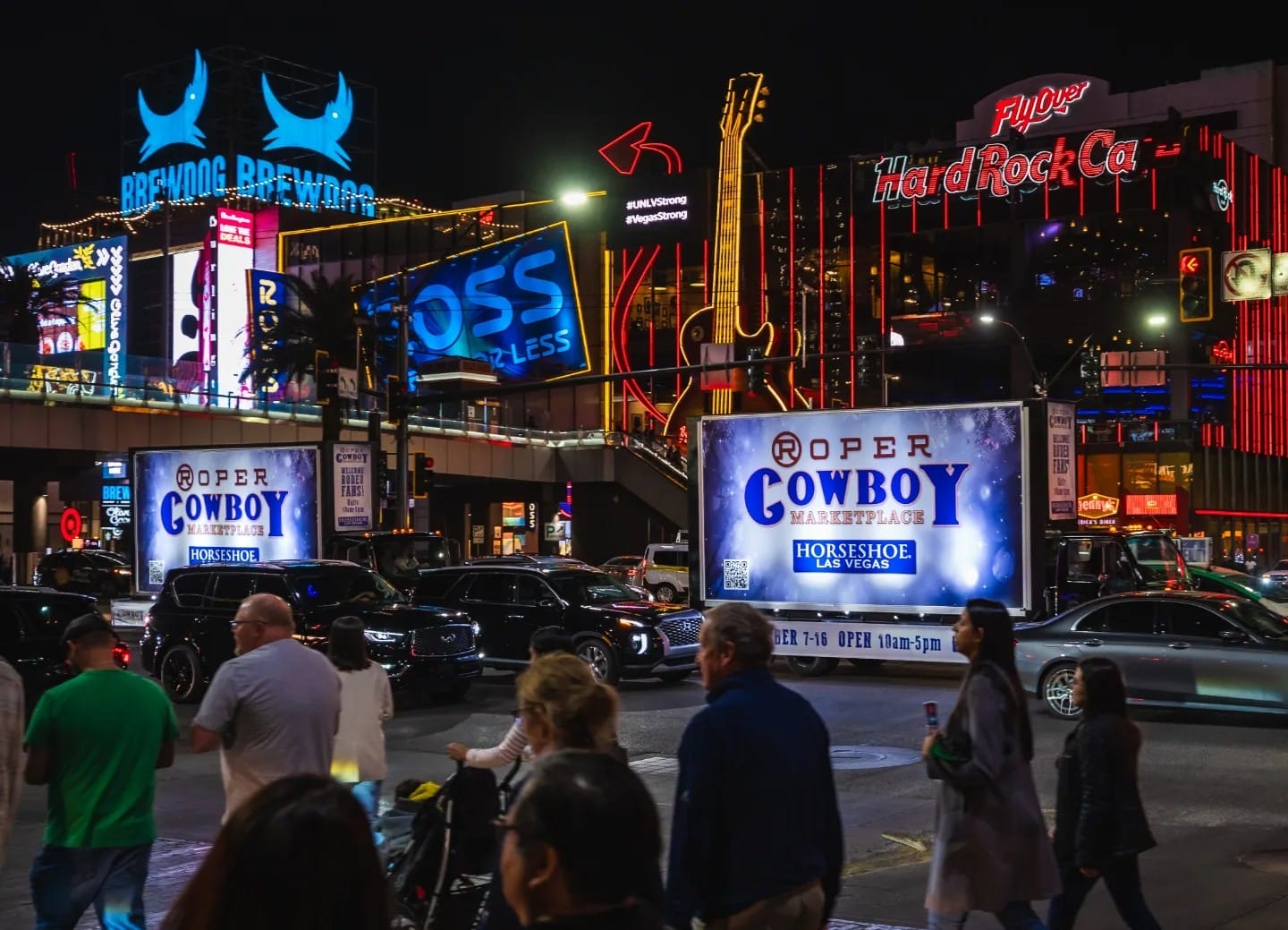 Bustling Las Vegas street scene at night with neon signs.