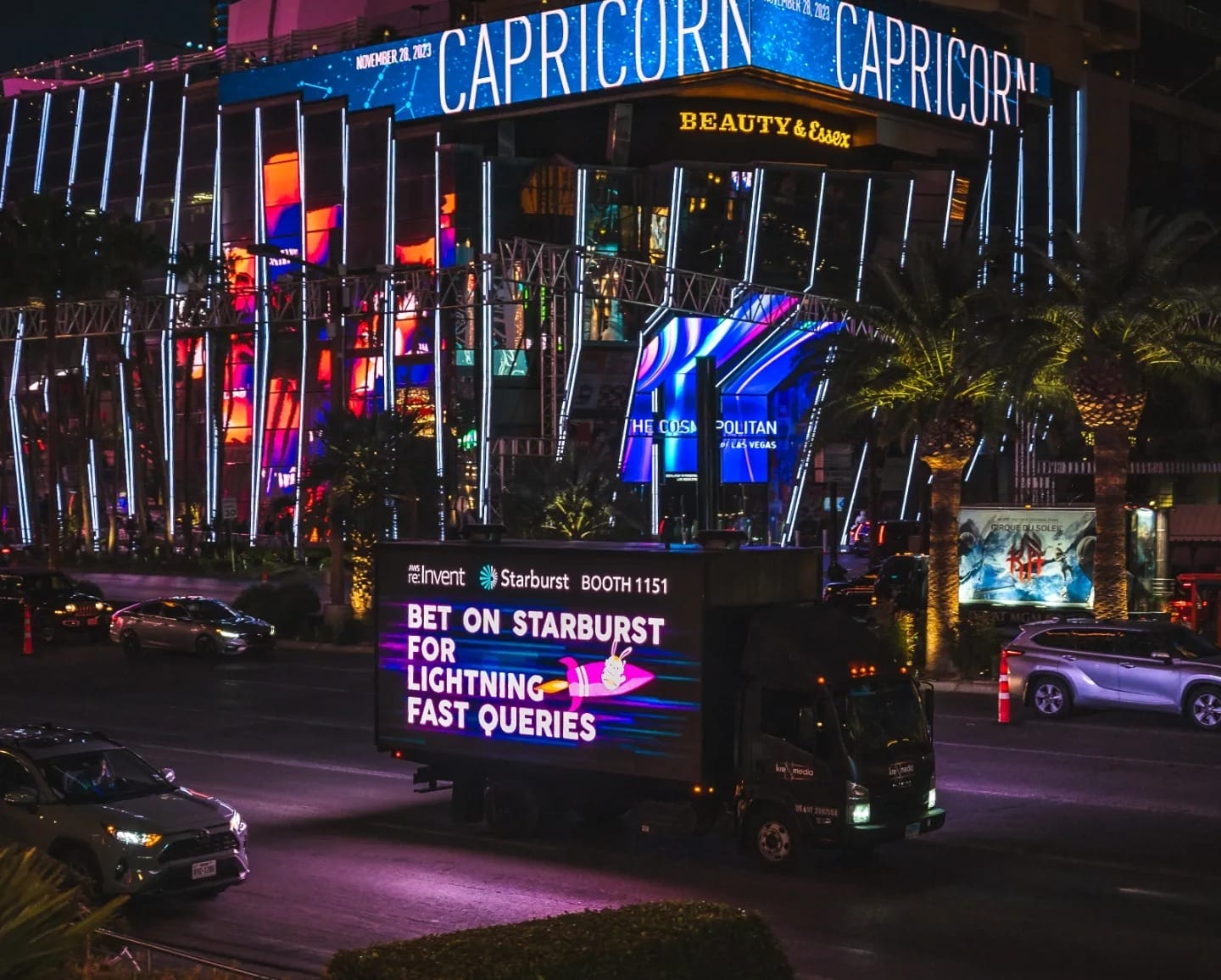 Neon-lit Vegas street view with mobile advertisement truck.