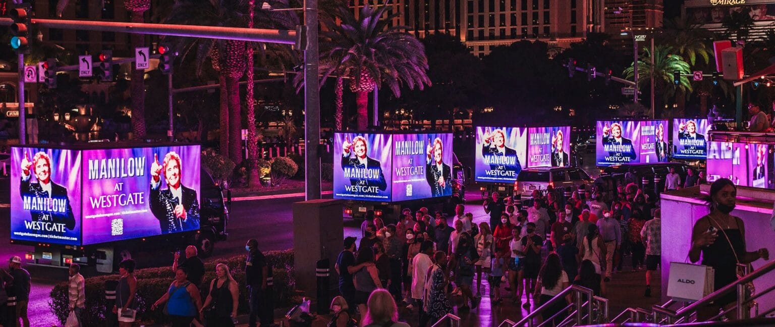 Las Vegas Strip at night with illuminated billboards.
