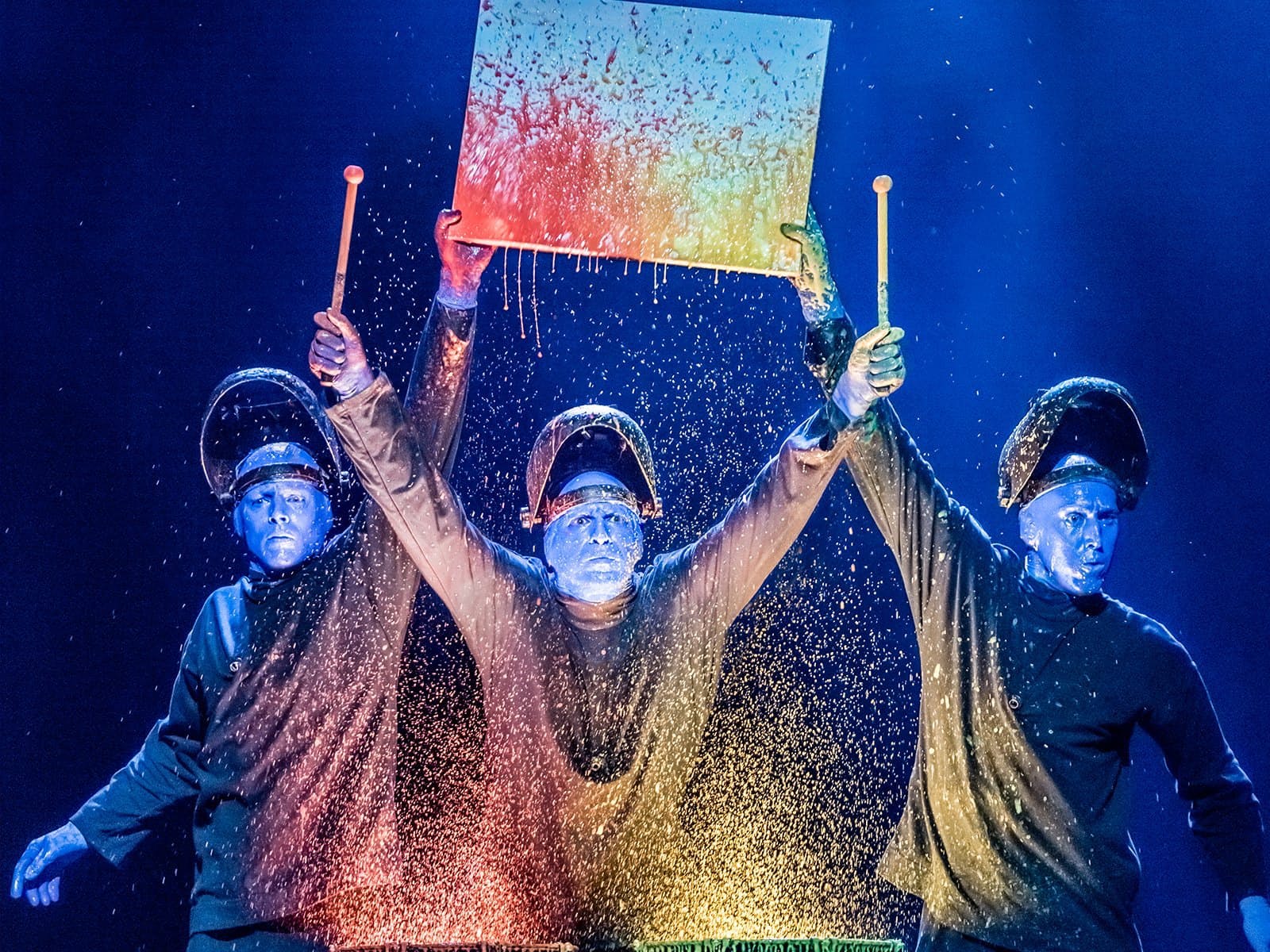 Blue Man Group splashing colorful paint during dynamic show