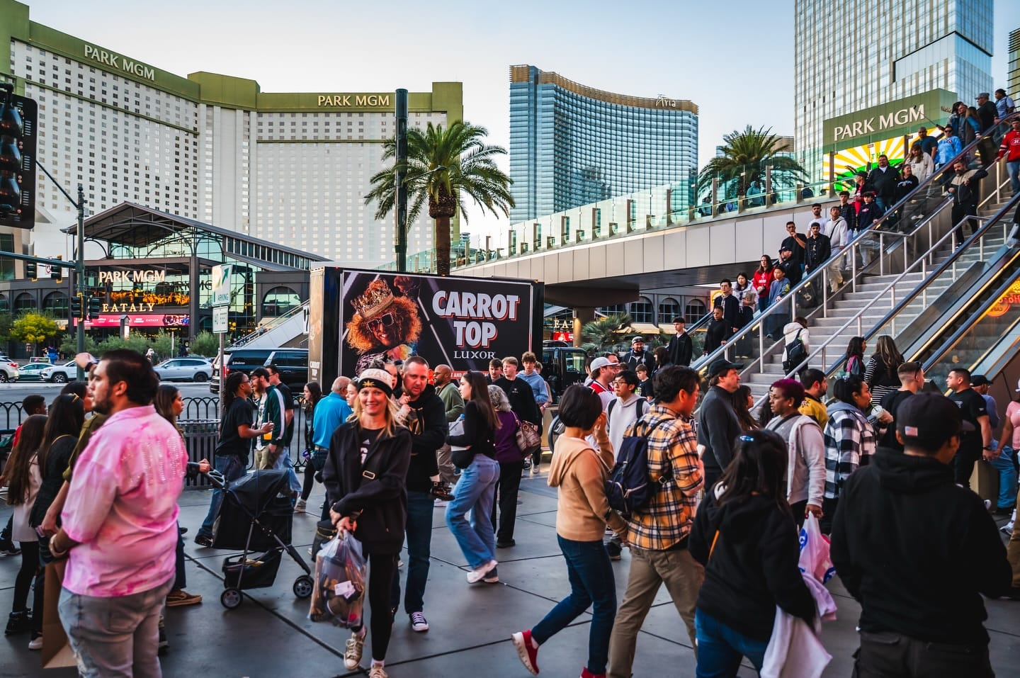 Crowds nearby a mobile billboard display of Carrot Top